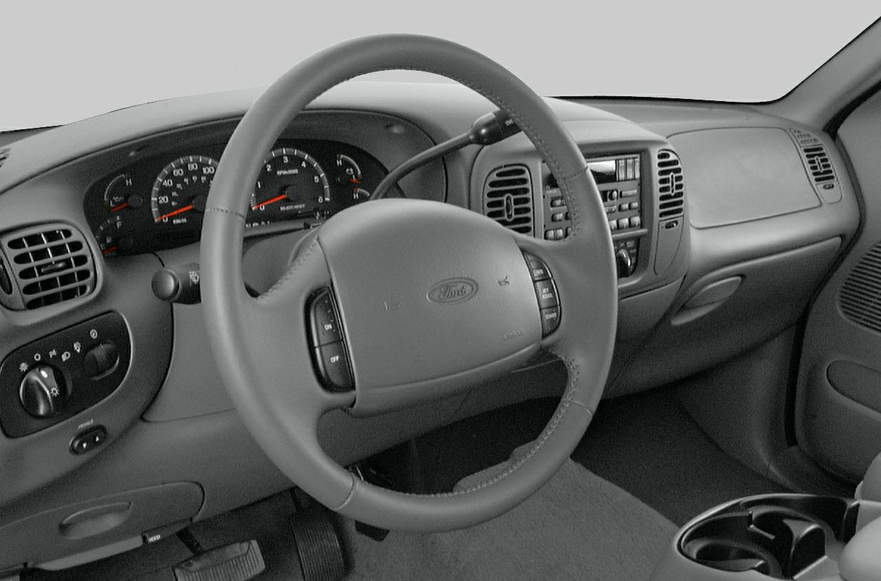 Dashboard, steering wheel, gauges, and center console controls of a truck interior