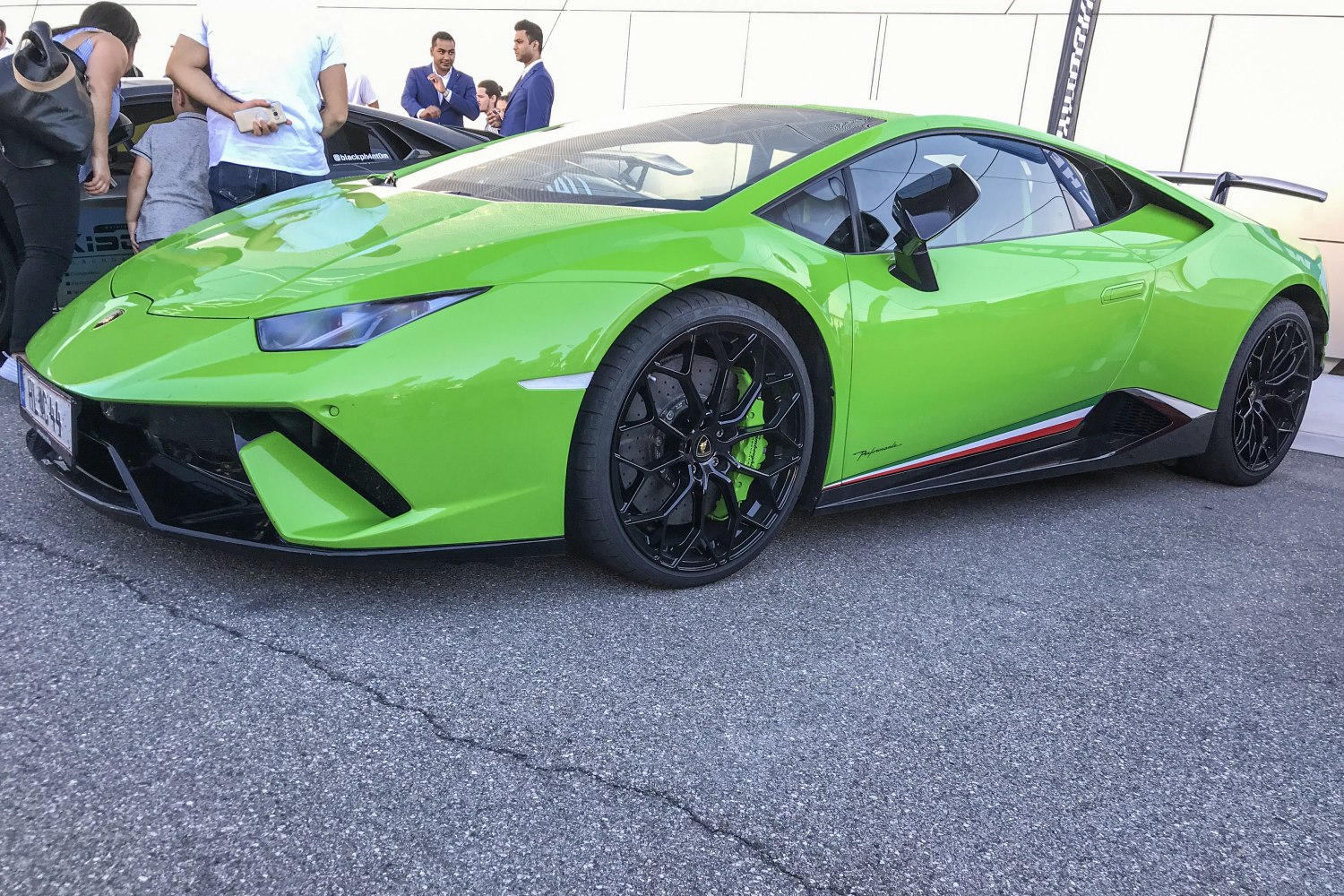 Sharp headlights and black multi-spoke wheels from front-side angle