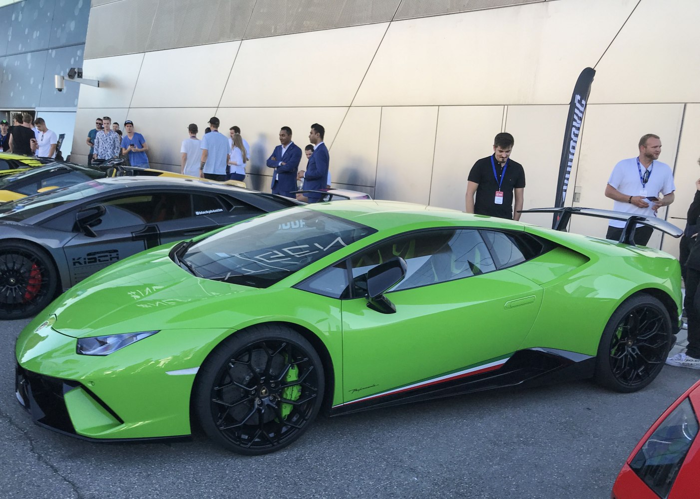 Green sports coupe with black alloy wheels and large rear spoiler