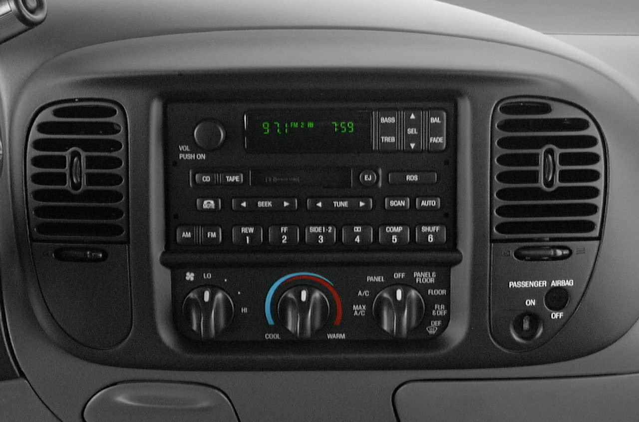 Car radio and climate control panel with analog knobs and digital display
