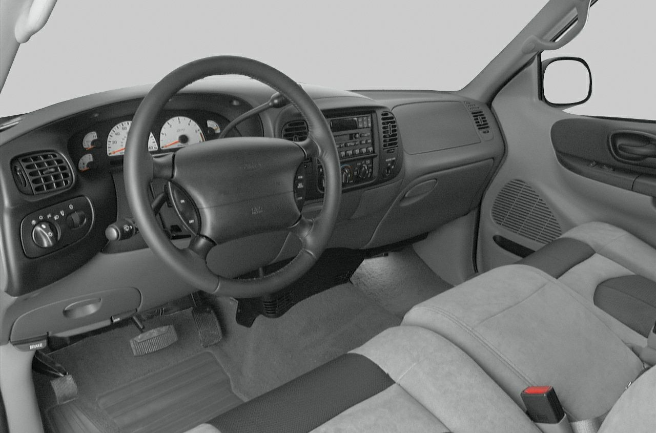Dashboard, steering wheel, cloth seats, center console in truck interior