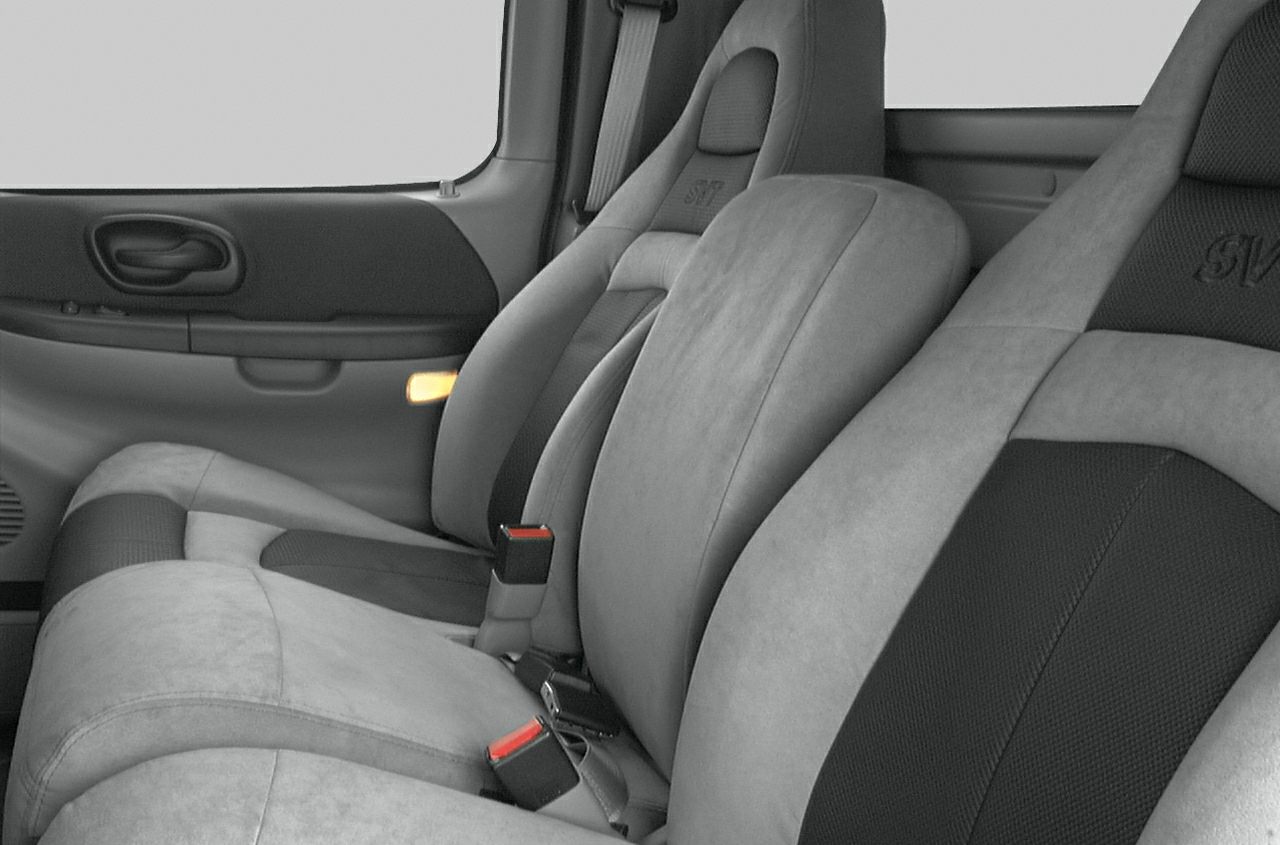 Close-up of interior seating and door panel featuring upholstery and seatbelts.