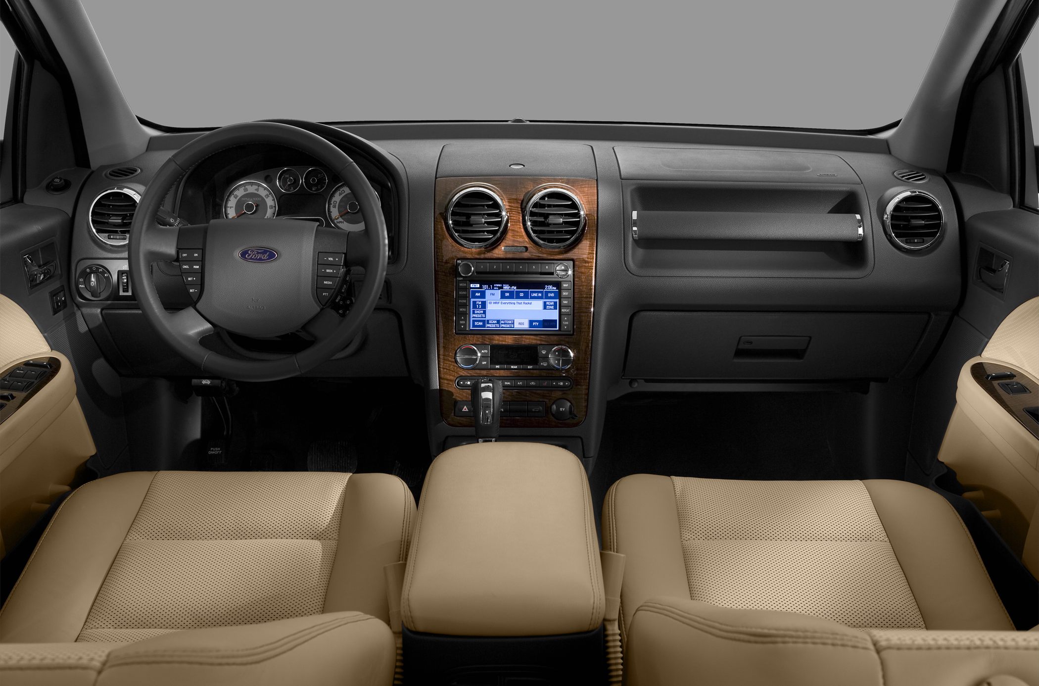 Dashboard, steering wheel, center console with wood trim and beige leather seats