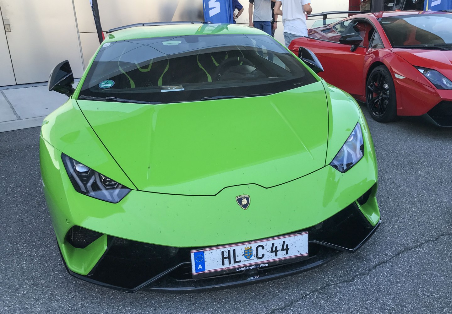 Green sports car front with sharp headlights and aerodynamic features.