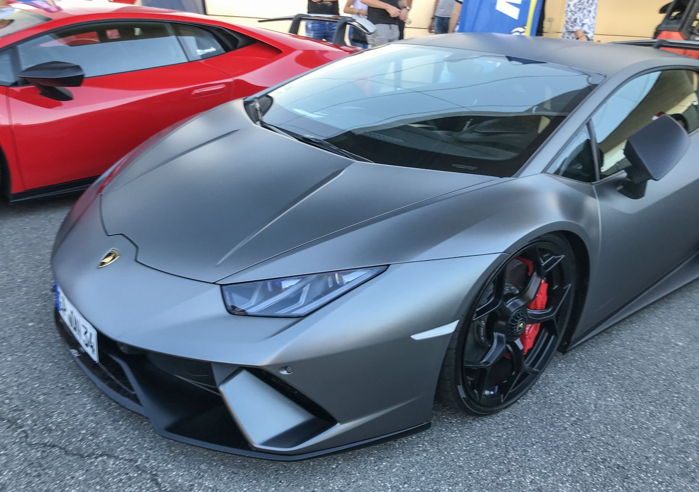 Matte grey front fascia and detailed wheel with red brake caliper.