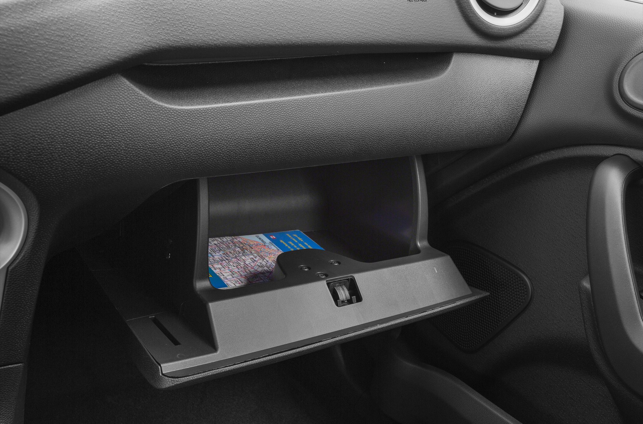 Open glovebox with map inside in a car interior