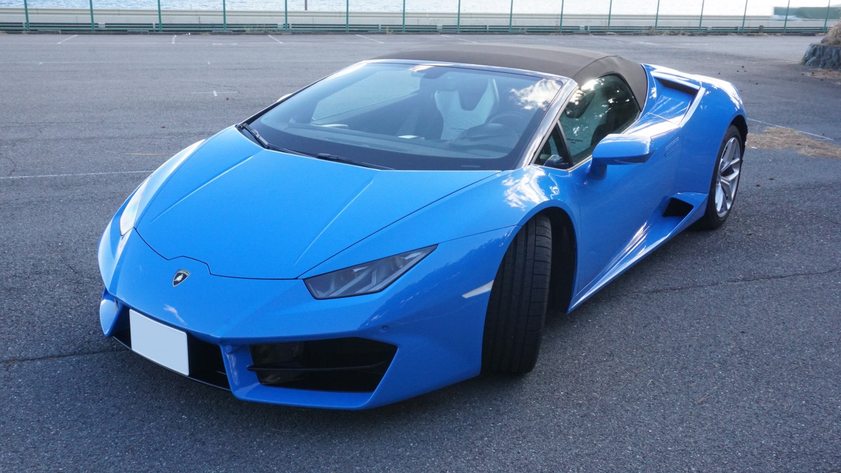 Blue convertible with sleek aerodynamic front and side view.