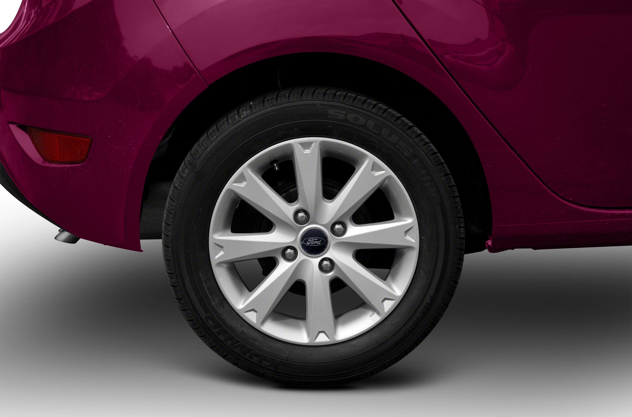 Silver alloy wheel and tire on rear wheel arch of compact hatchback