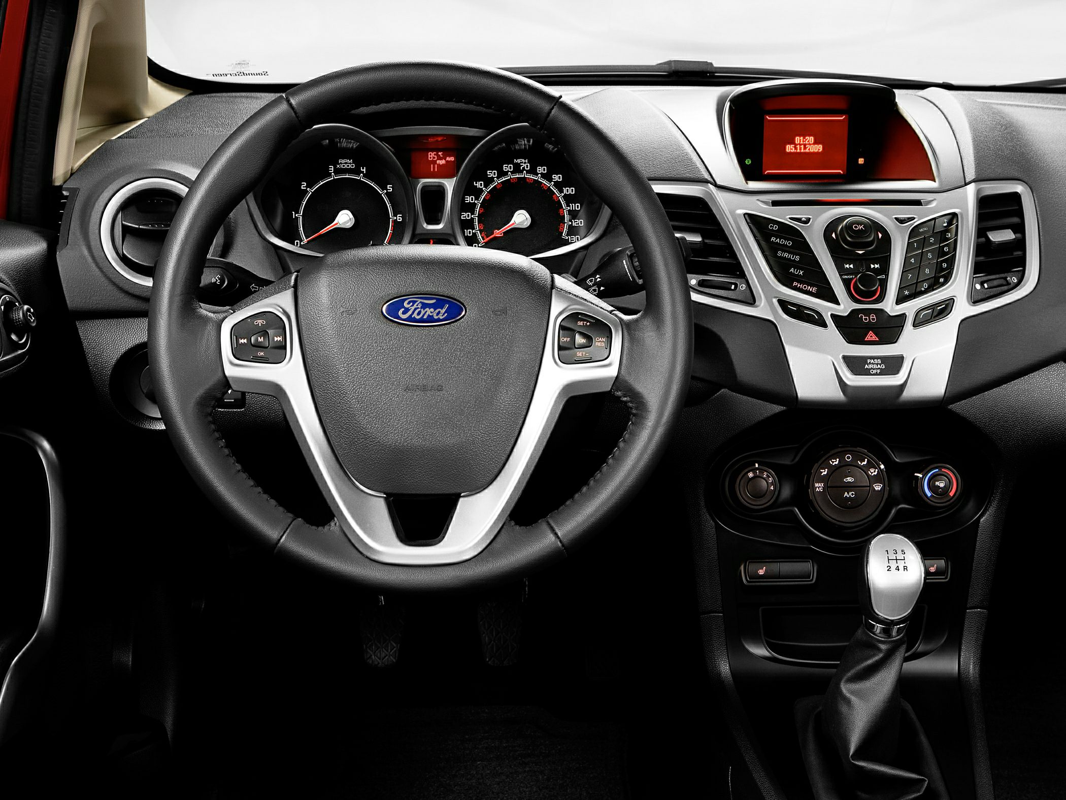 Dashboard and steering wheel with manual gear shift, central control panel, and instrument cluster
