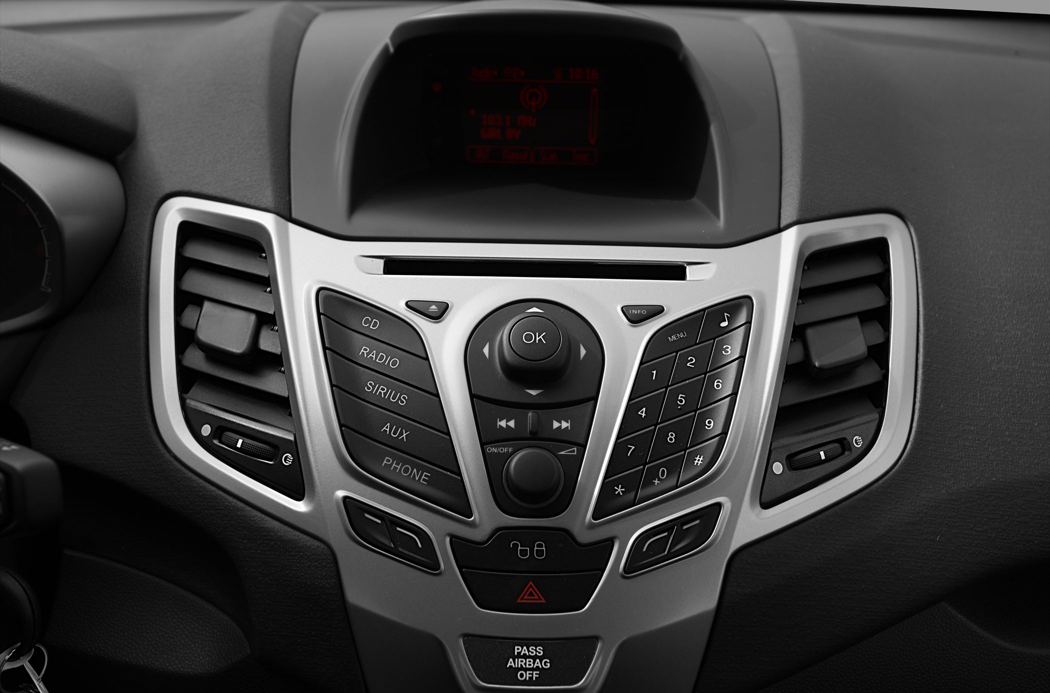 Center console with radio, media controls, and air vents