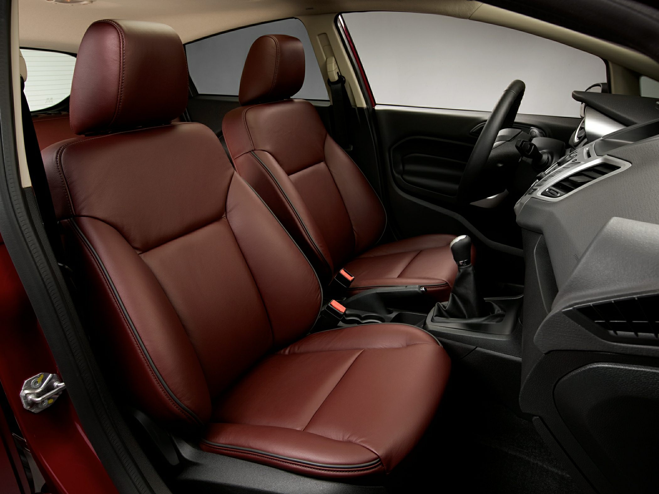 Brown leather seats with manual gearshift and detailed dashboard.