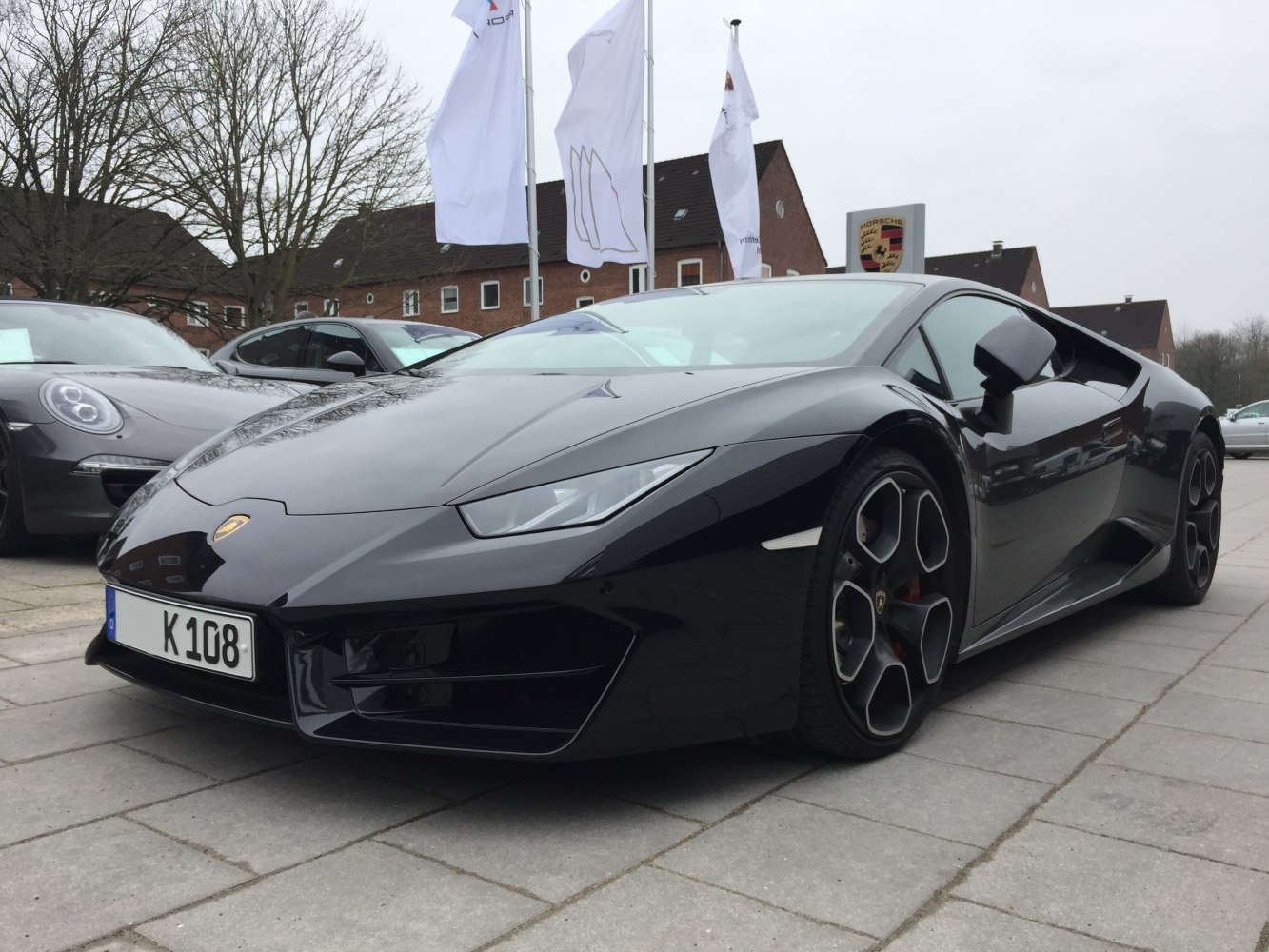 Front angle of a sleek black sporty coupe with multi-spoke alloy wheels
