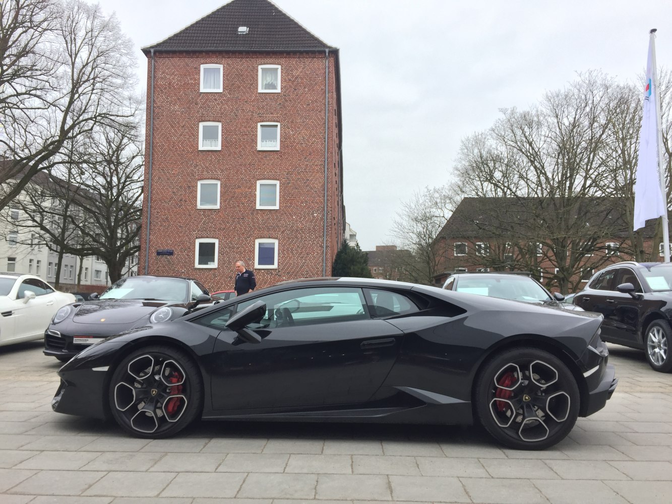 Sleek black sports car side profile with distinctive rims and aerodynamic shape