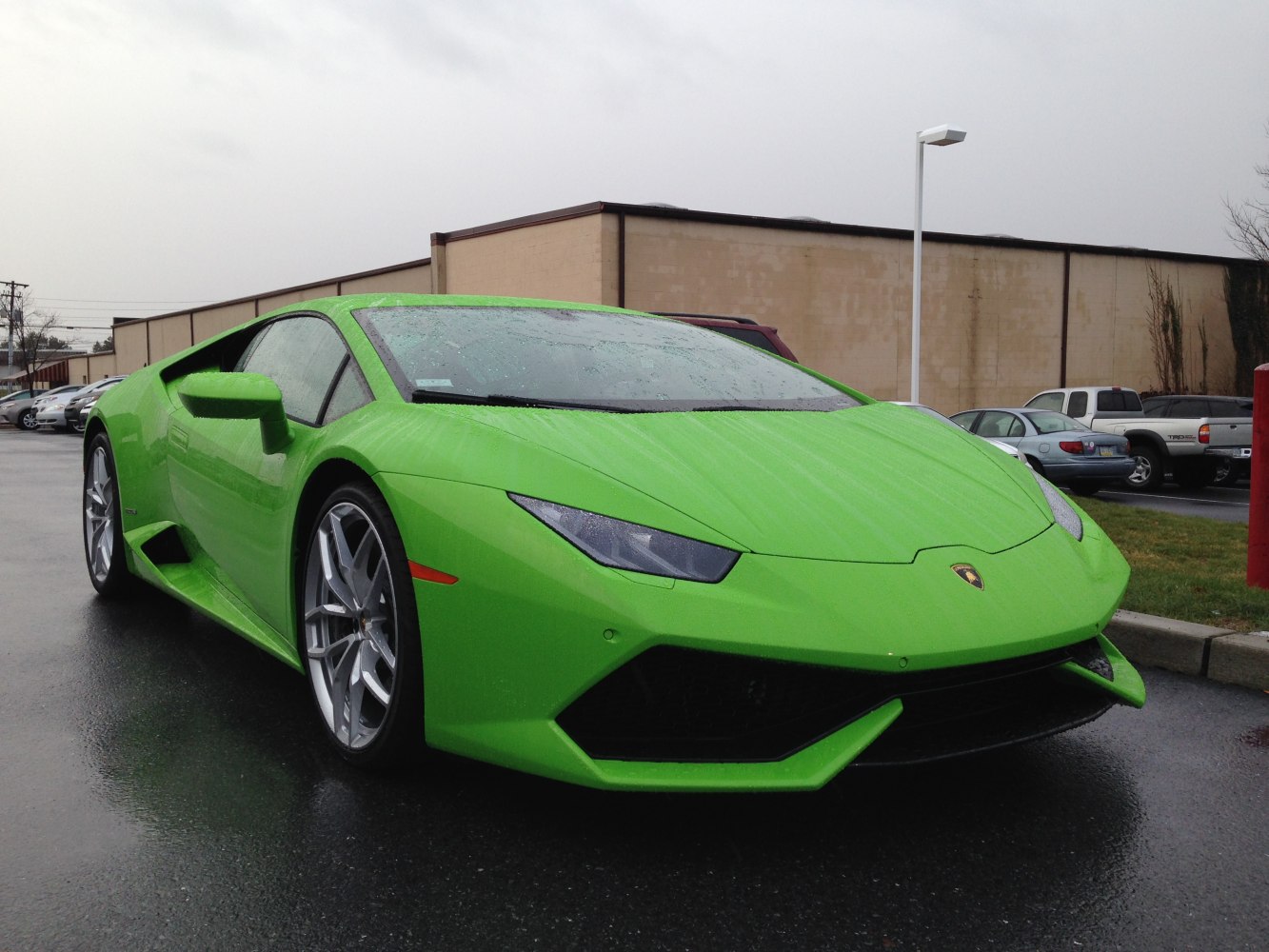 Front angle view of a green sports car with sharp headlights and aerodynamic design