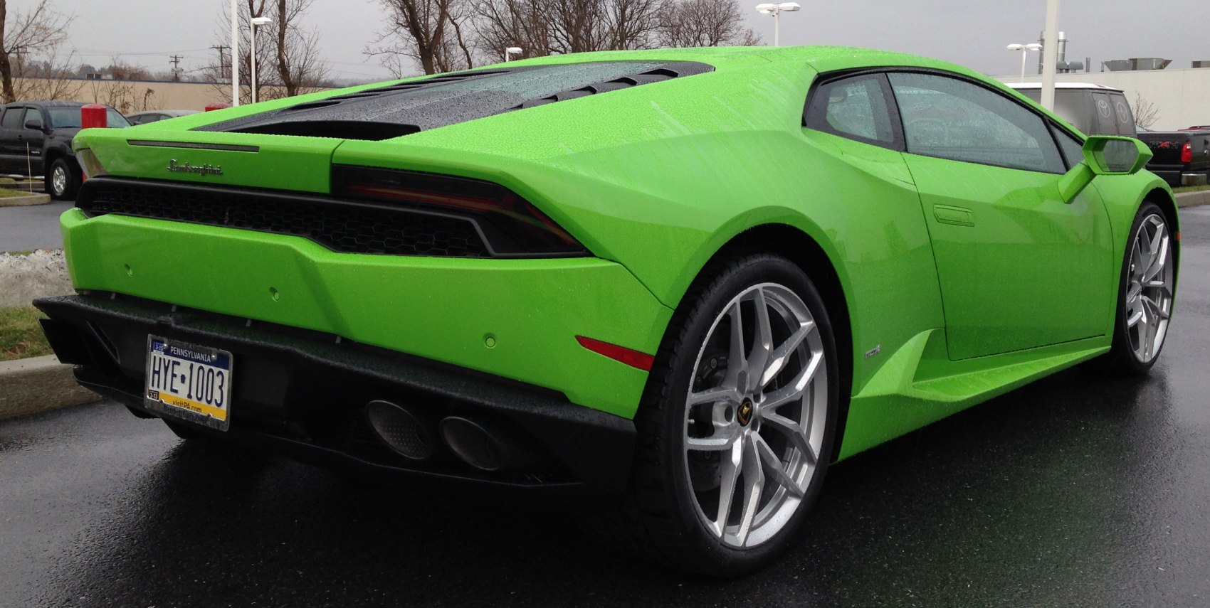 Rear and side view of a vivid green sports car with alloy wheels