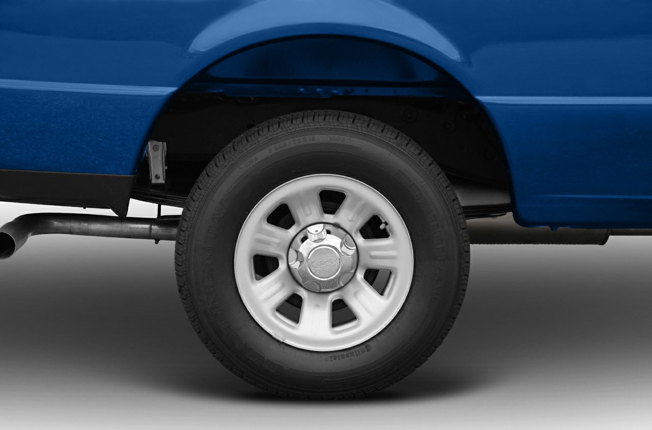 Rear wheel with steel rim and visible exhaust pipe