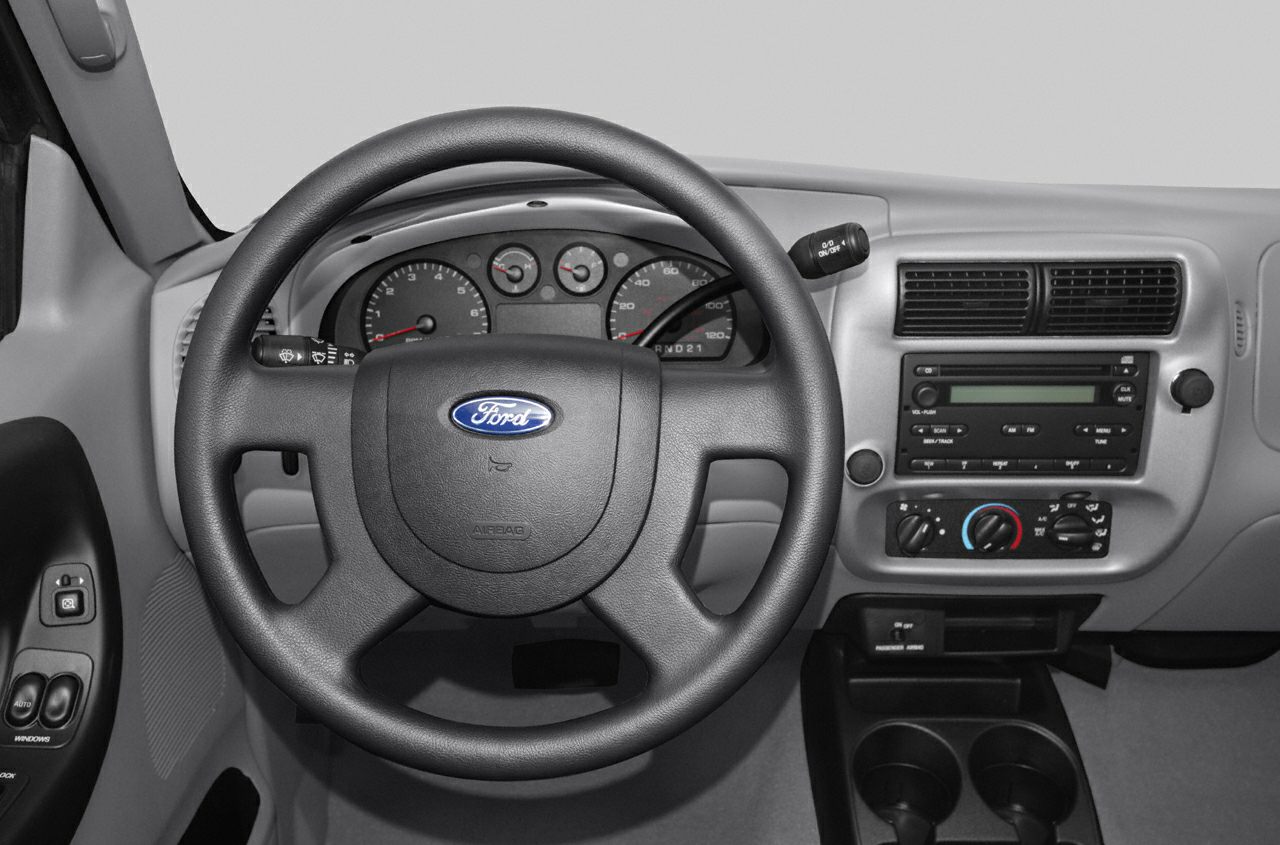 Steering wheel and dashboard with gauges, audio system, and controls.