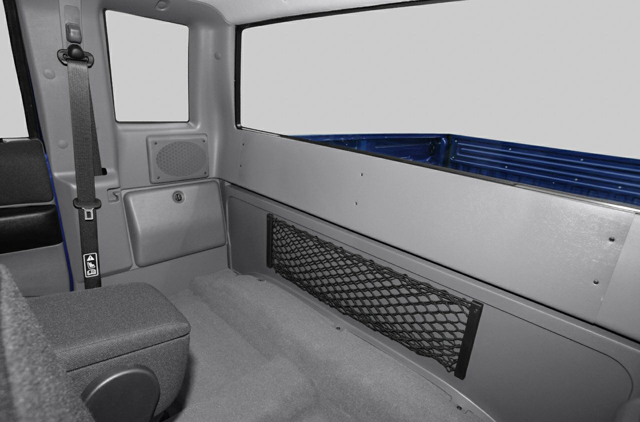 Rear seating area with seat belt, storage net, and interior paneling in pickup cabin