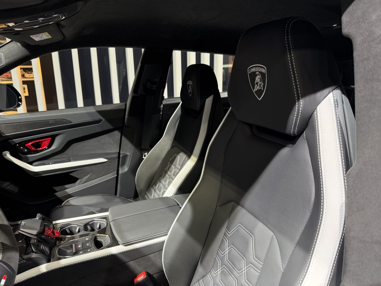 Luxury sports seats with stitched upholstery and logo headrests.