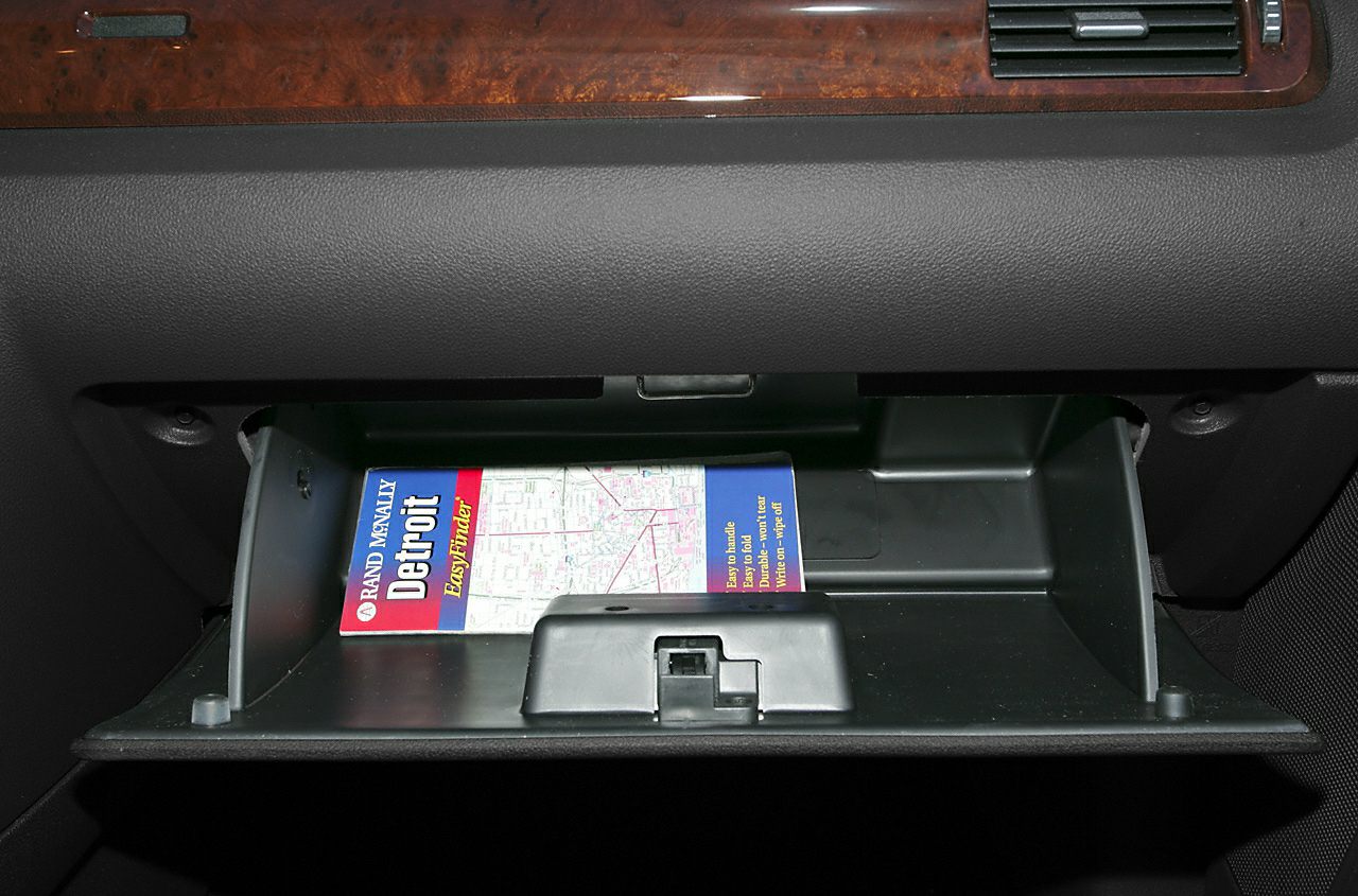 Open glove compartment with a Detroit city map inside.