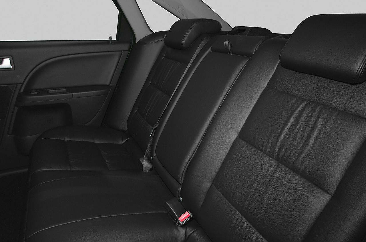 Rear leather bench seat with headrests and seat belts.