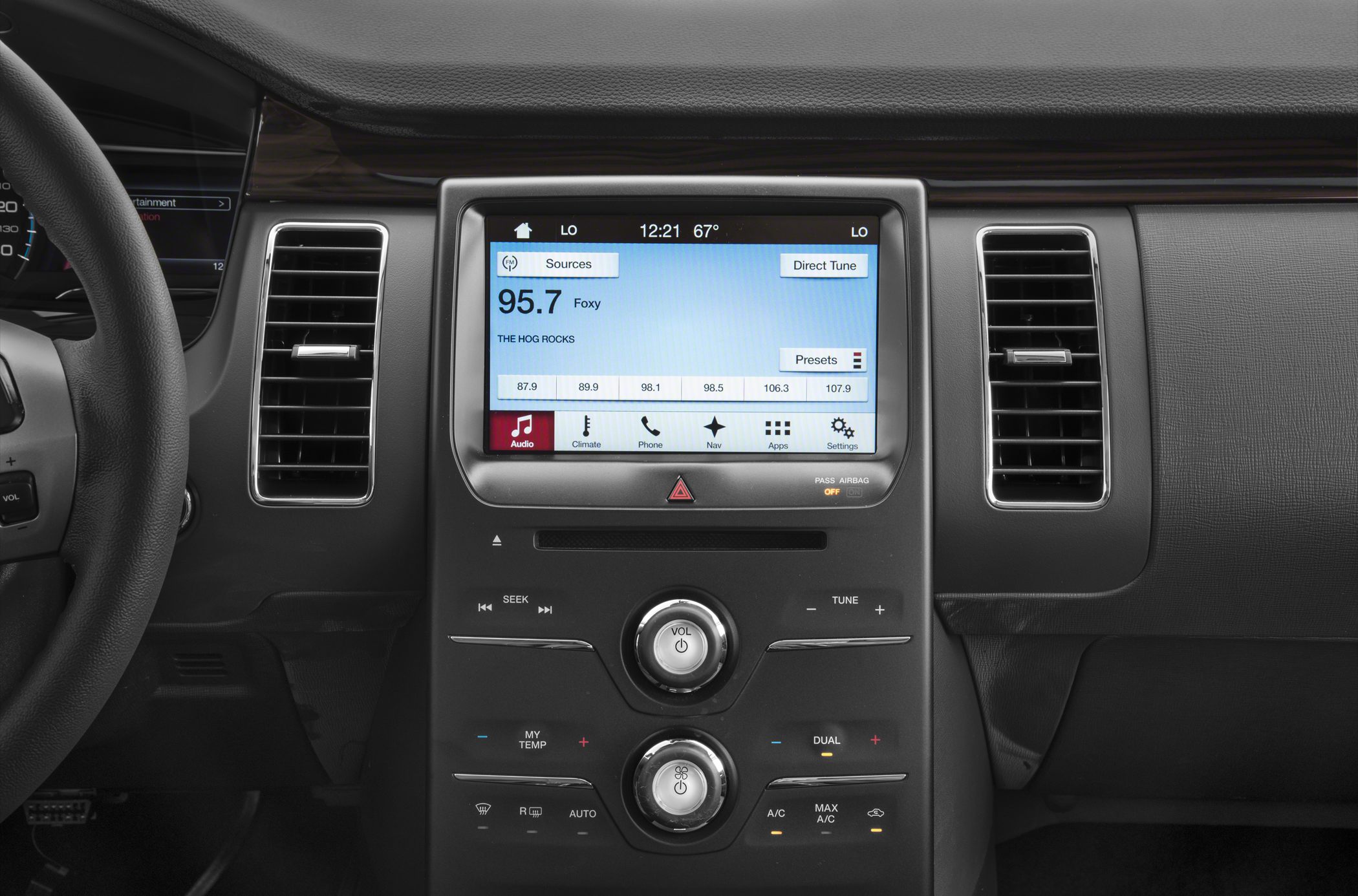 Touchscreen infotainment system with dual climate control knobs.