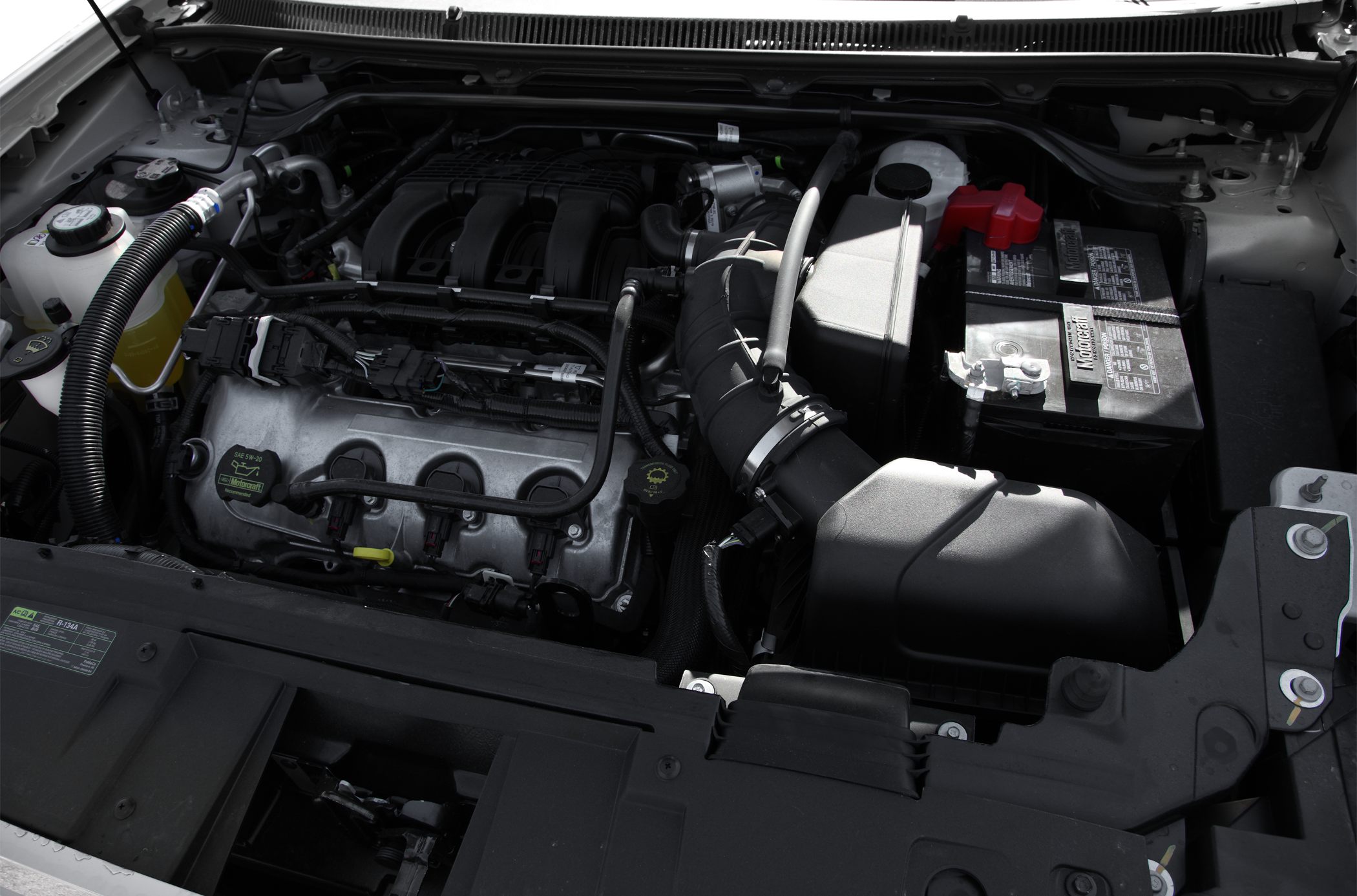 Engine compartment and battery layout with visible engine components