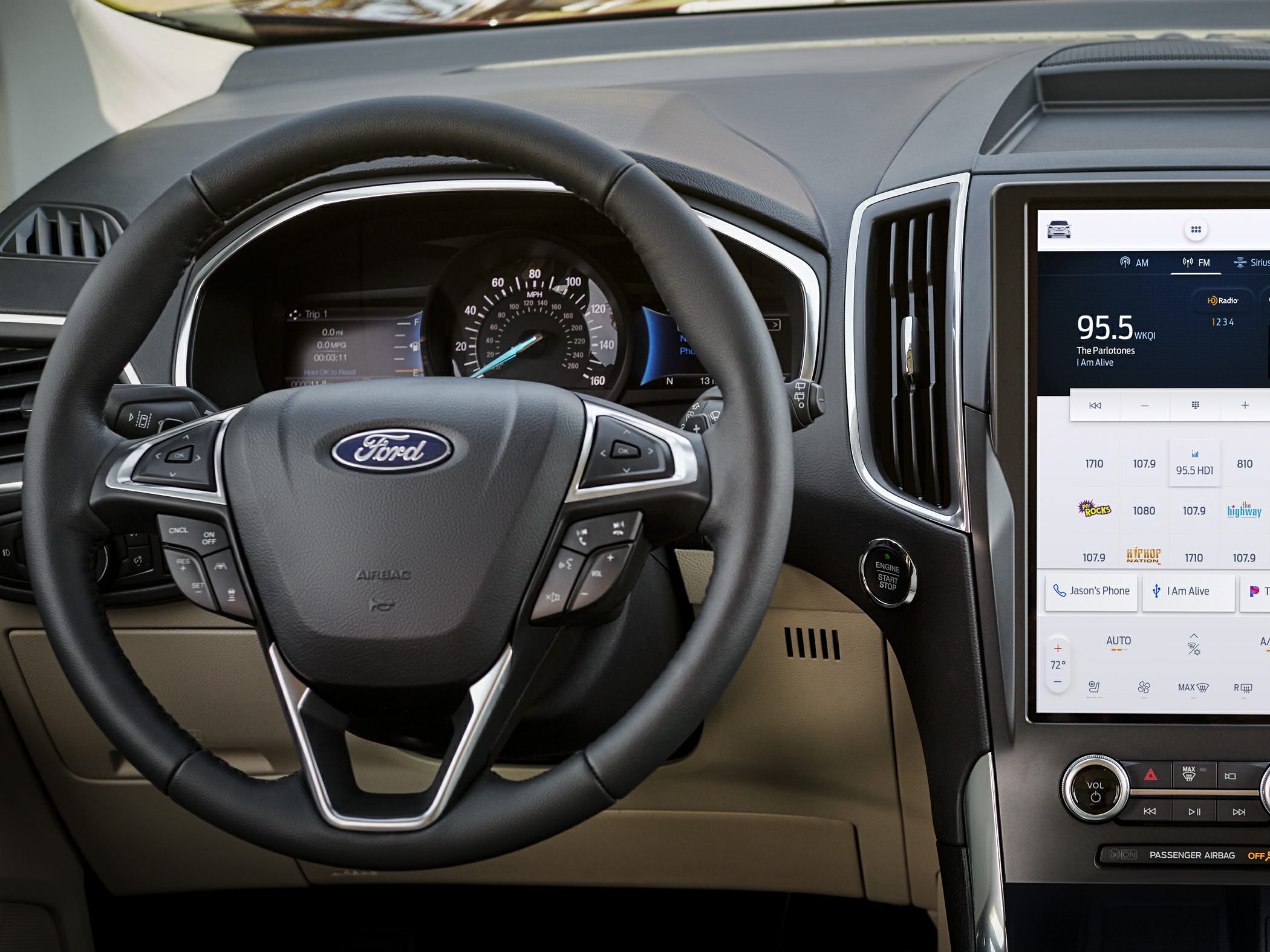 Steering wheel with controls and digital gauge cluster alongside a touchscreen infotainment display