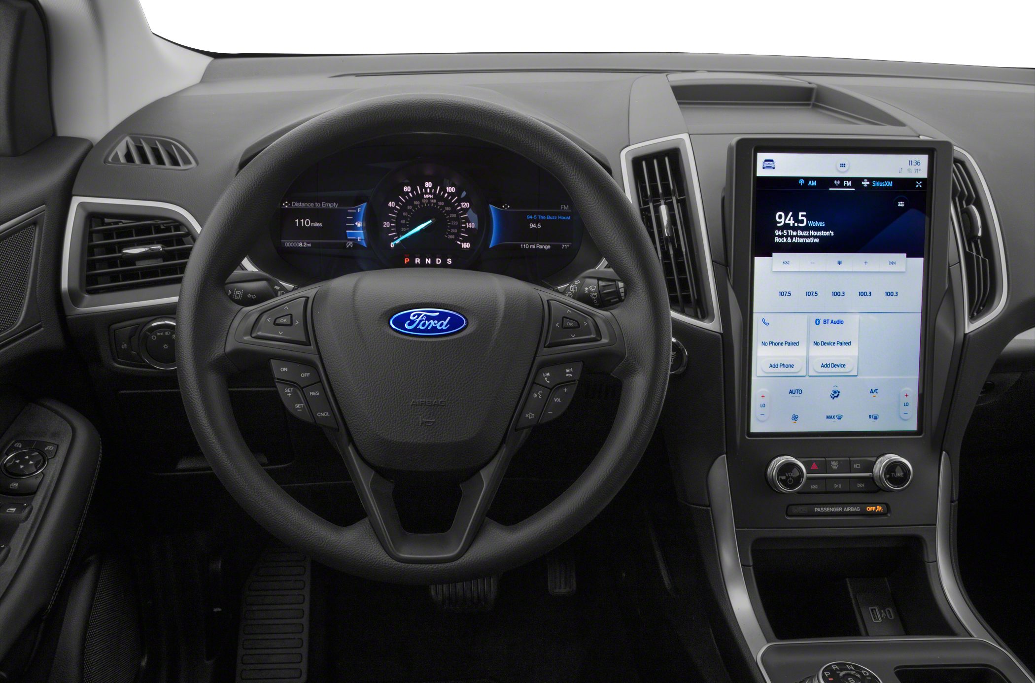 Steering wheel with control buttons and large vertical touchscreen display.