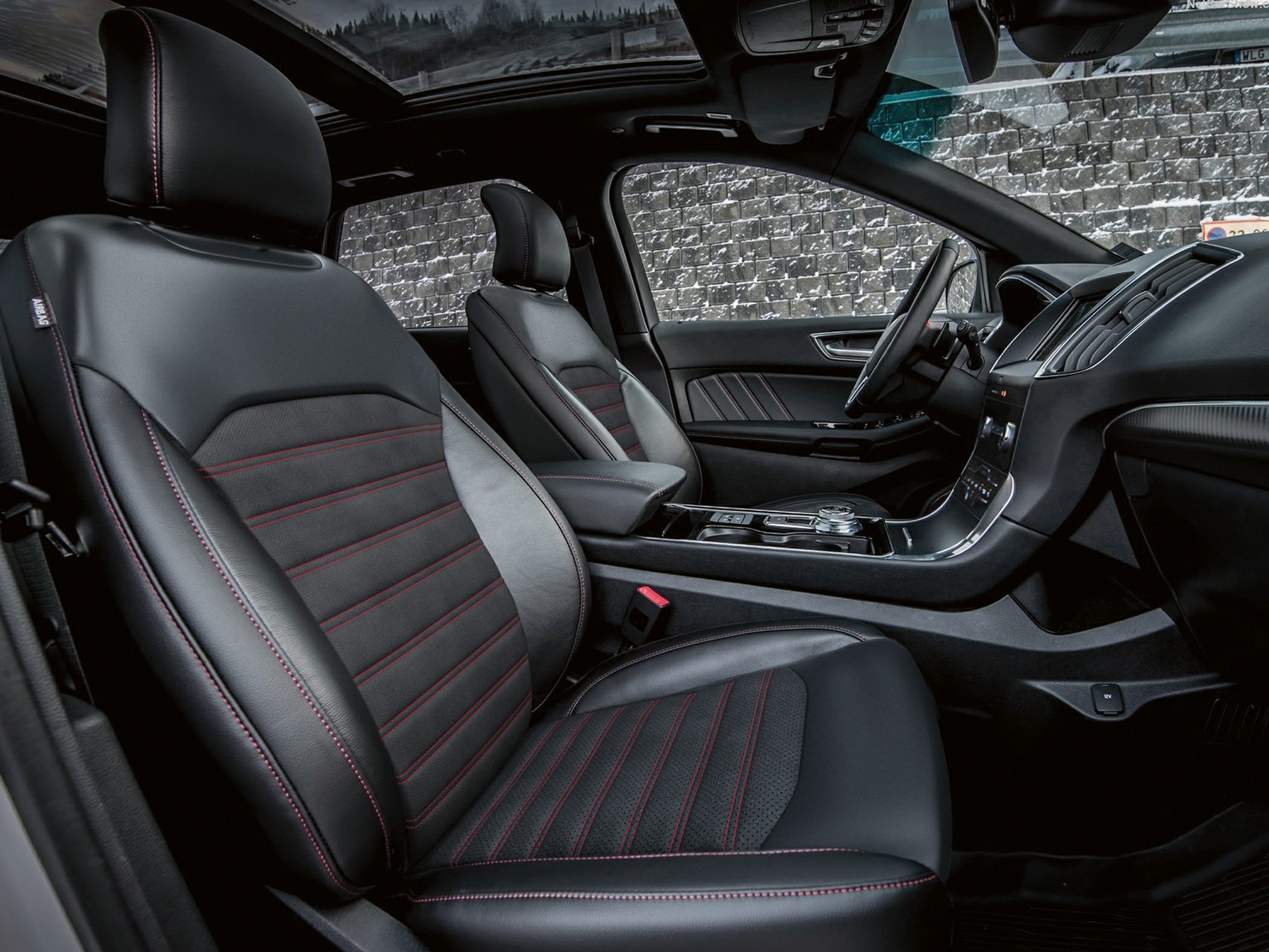 Premium black leather seats with red stitching and panoramic roof