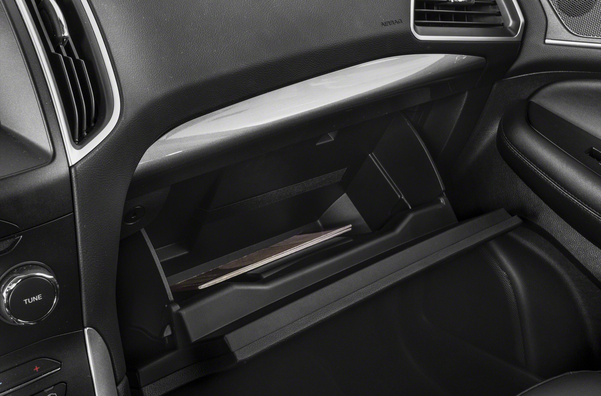 Open glove box and dashboard controls featuring tune knob