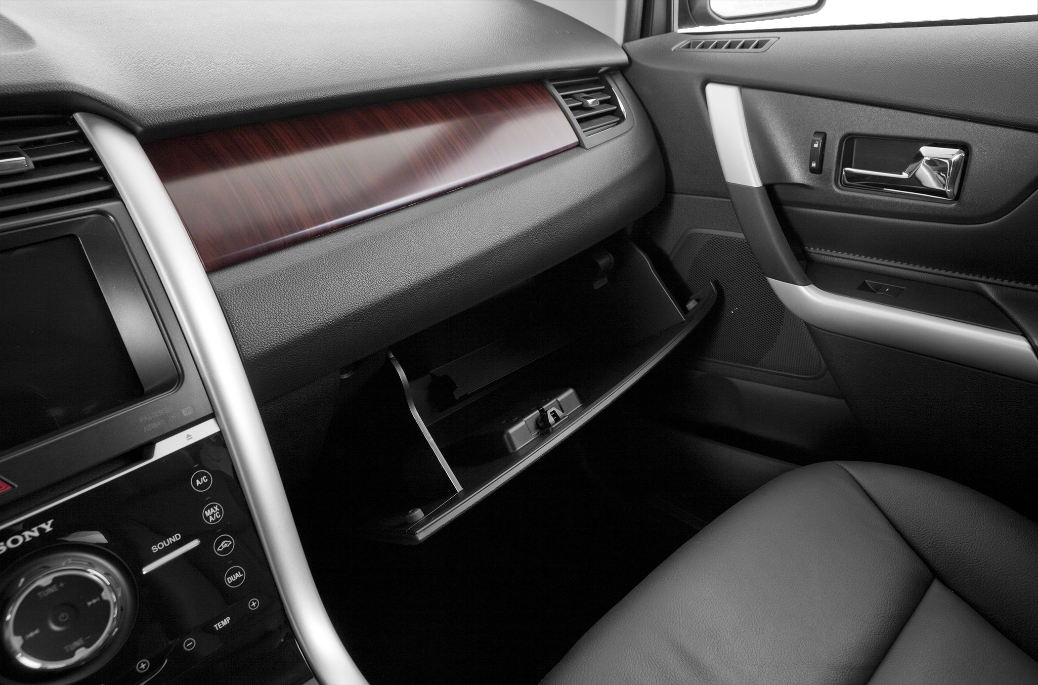 Dashboard with wood trim and open glovebox in car interior