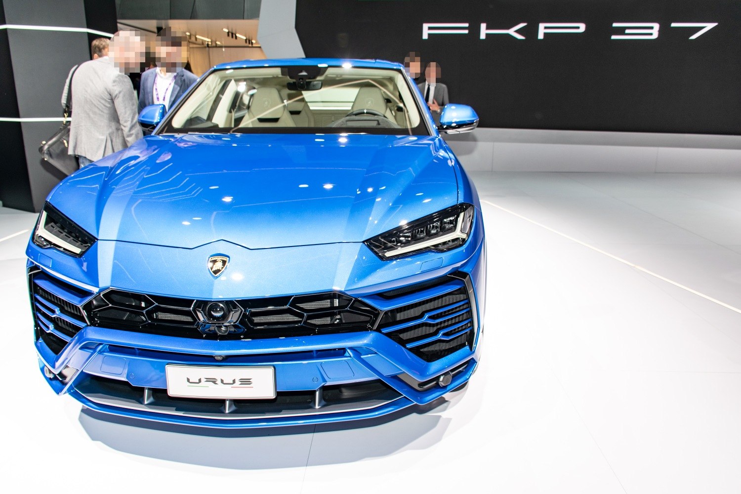 Blue vehicle front with aggressive headlights and hexagonal grille