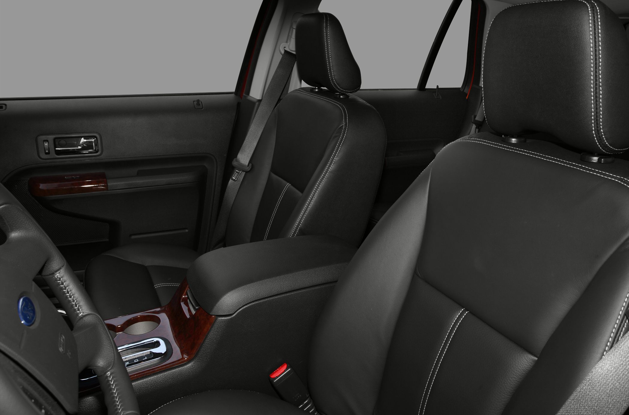 Black leather seats with white stitching and wood grain accents