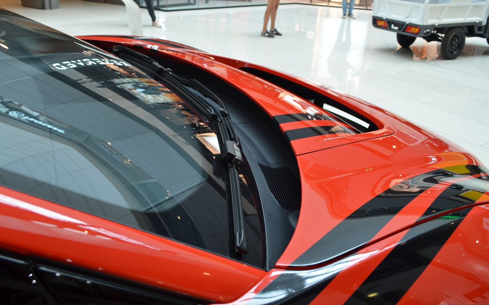 Windshield wipers and hood vent on a glossy car surface