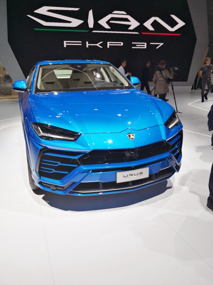 Front view of metallic blue SUV with angular headlights and sporty grille