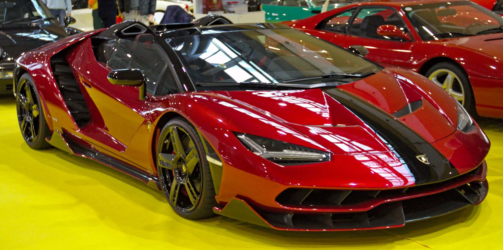 Red Lamborghini Centenario roadster with black carbon fibre stripe and sharp LED headlights