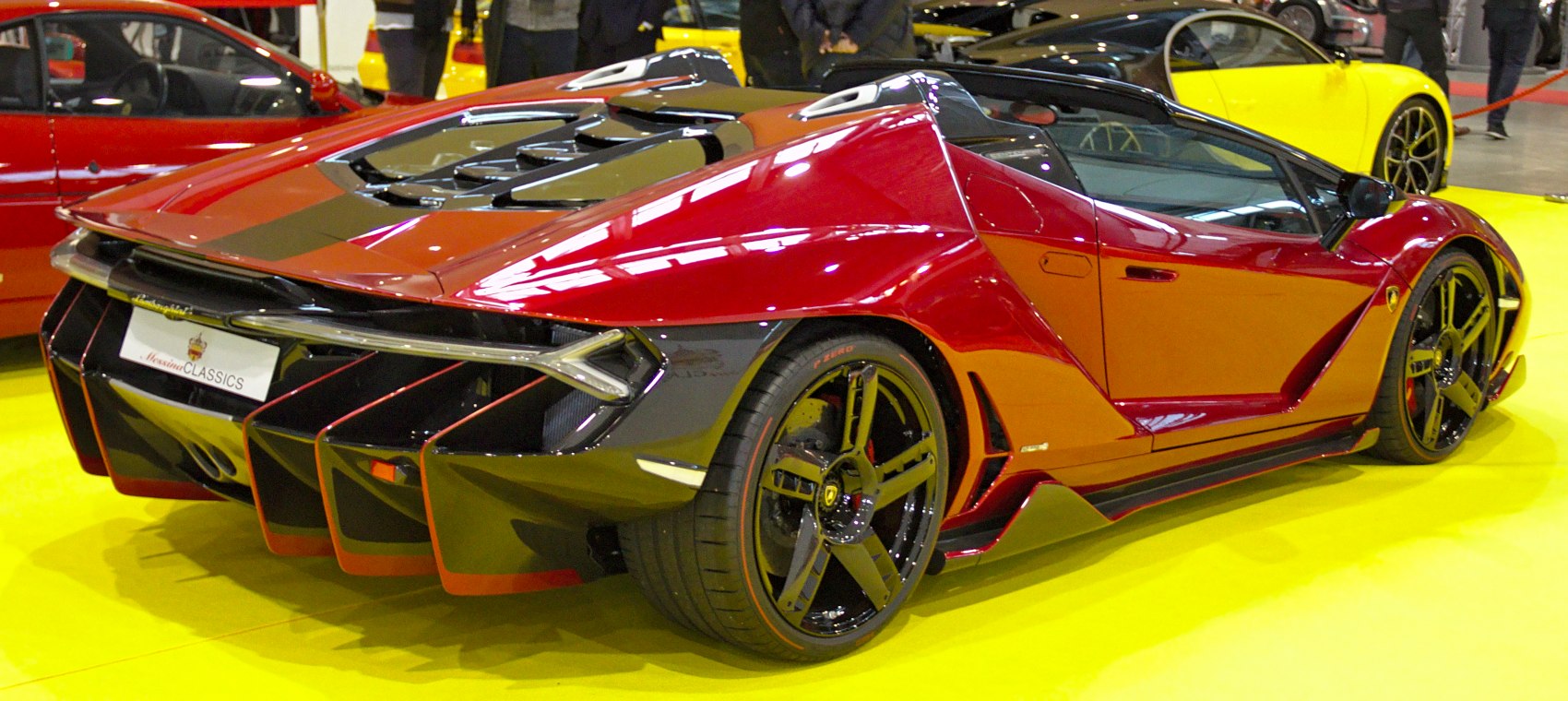 Rear diffuser, side air intakes, and black multi-spoke wheels on red roadster