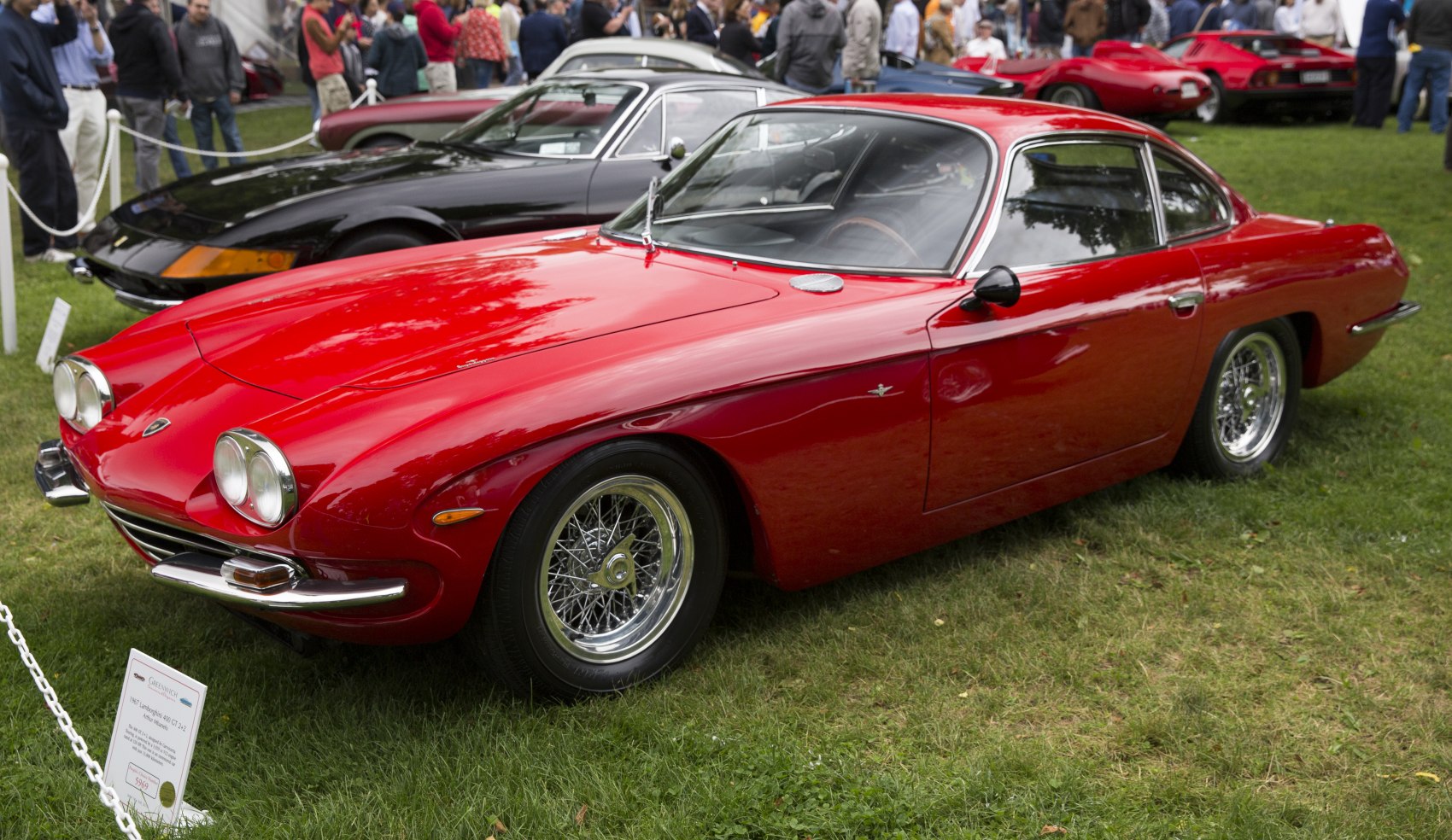 Dual round headlights, sleek coupe body, wire spoke wheels