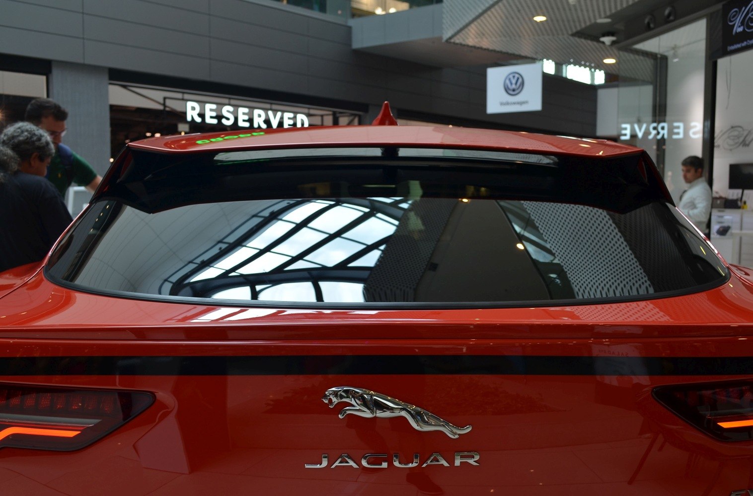 Rear view with Jaguar emblem, sleek spoiler, and distinctive tail lights