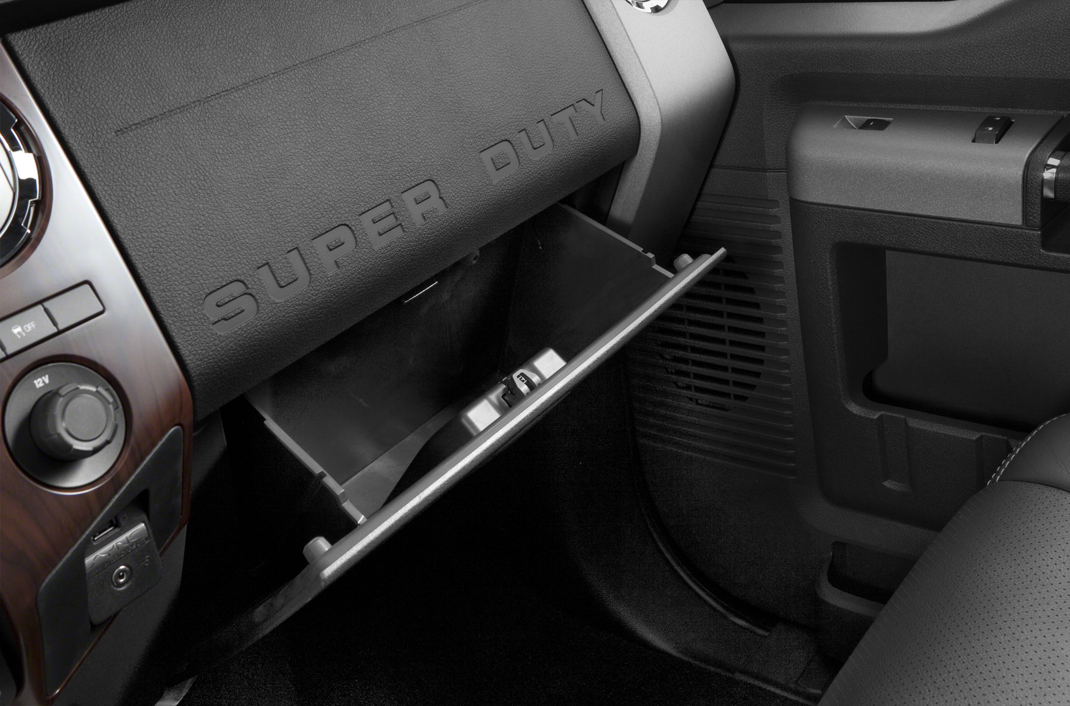 Open glovebox inside dashboard with embossed 'Super Duty' text.