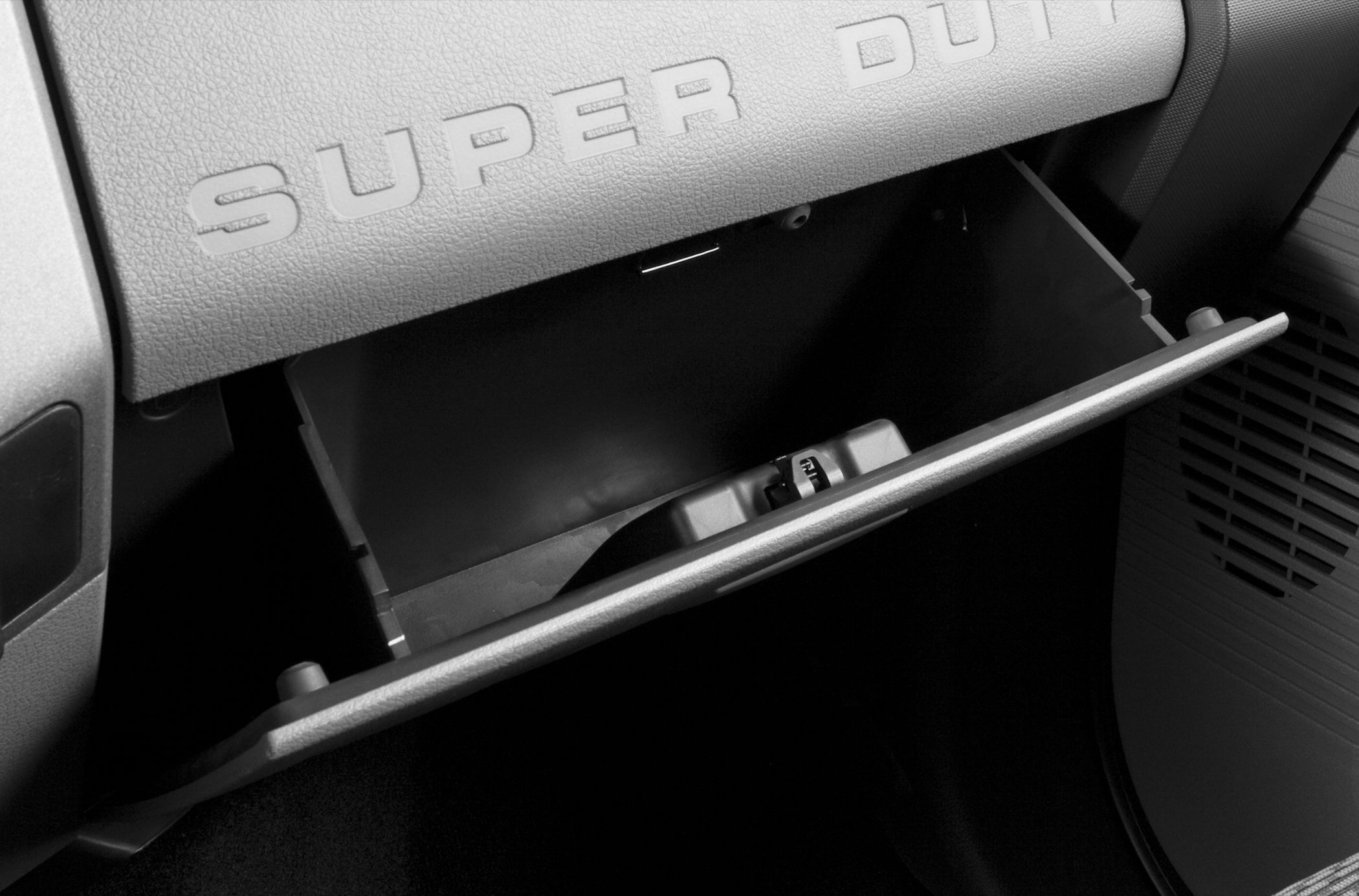 Open glove box with textured dashboard and embossed 'SUPER DUTY' lettering
