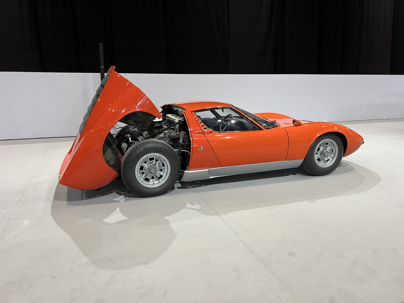 Side view with open rear hood exposing engine and rear wheel