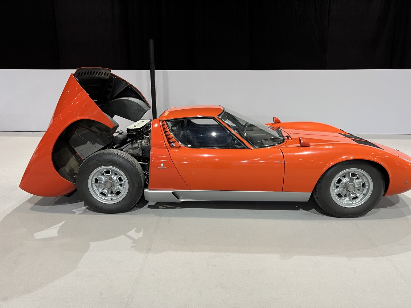 Mid-engine layout with open rear hatch and silver alloy wheels