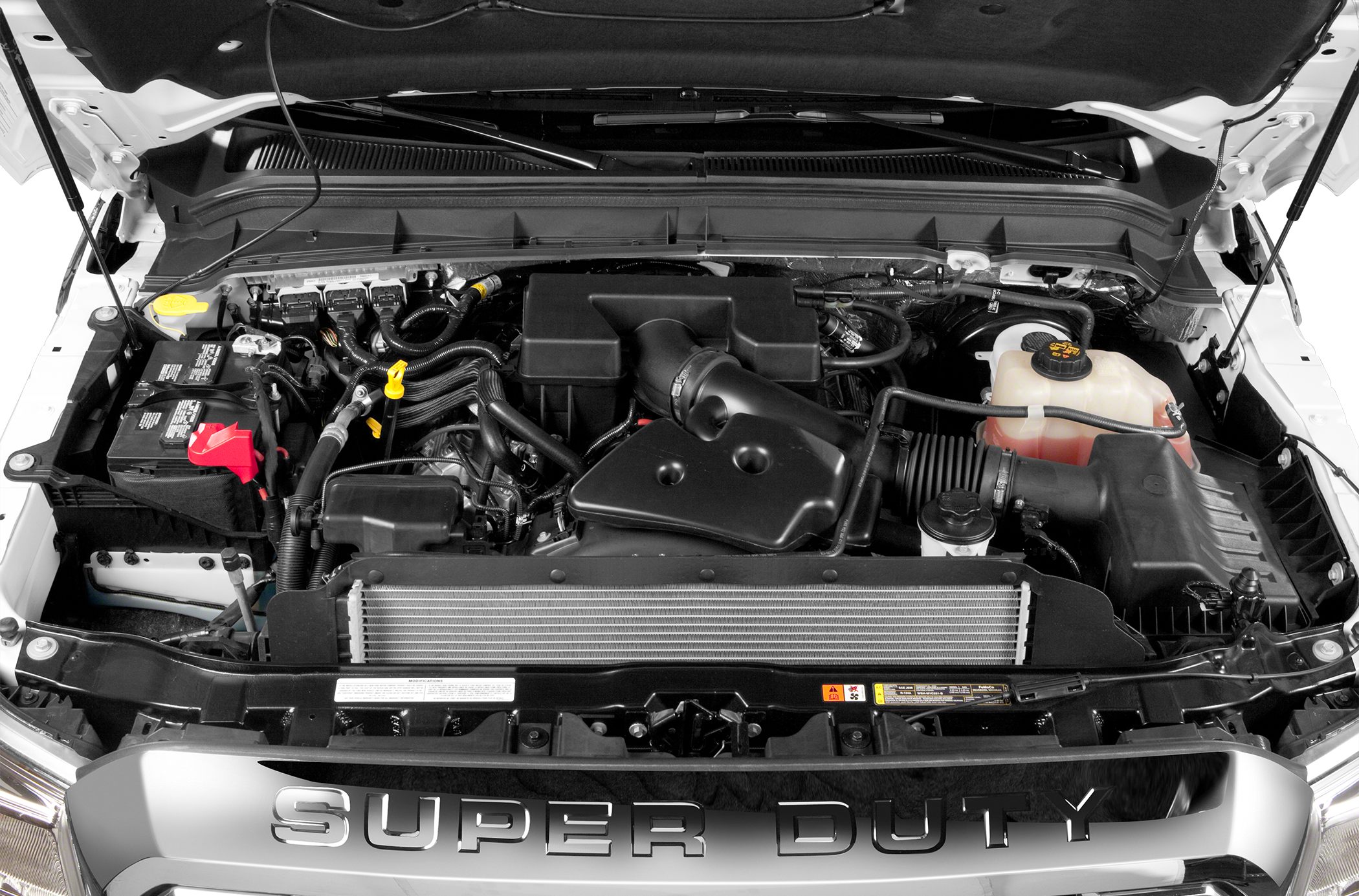 Engine compartment with battery, coolant reservoir, and air intake system.