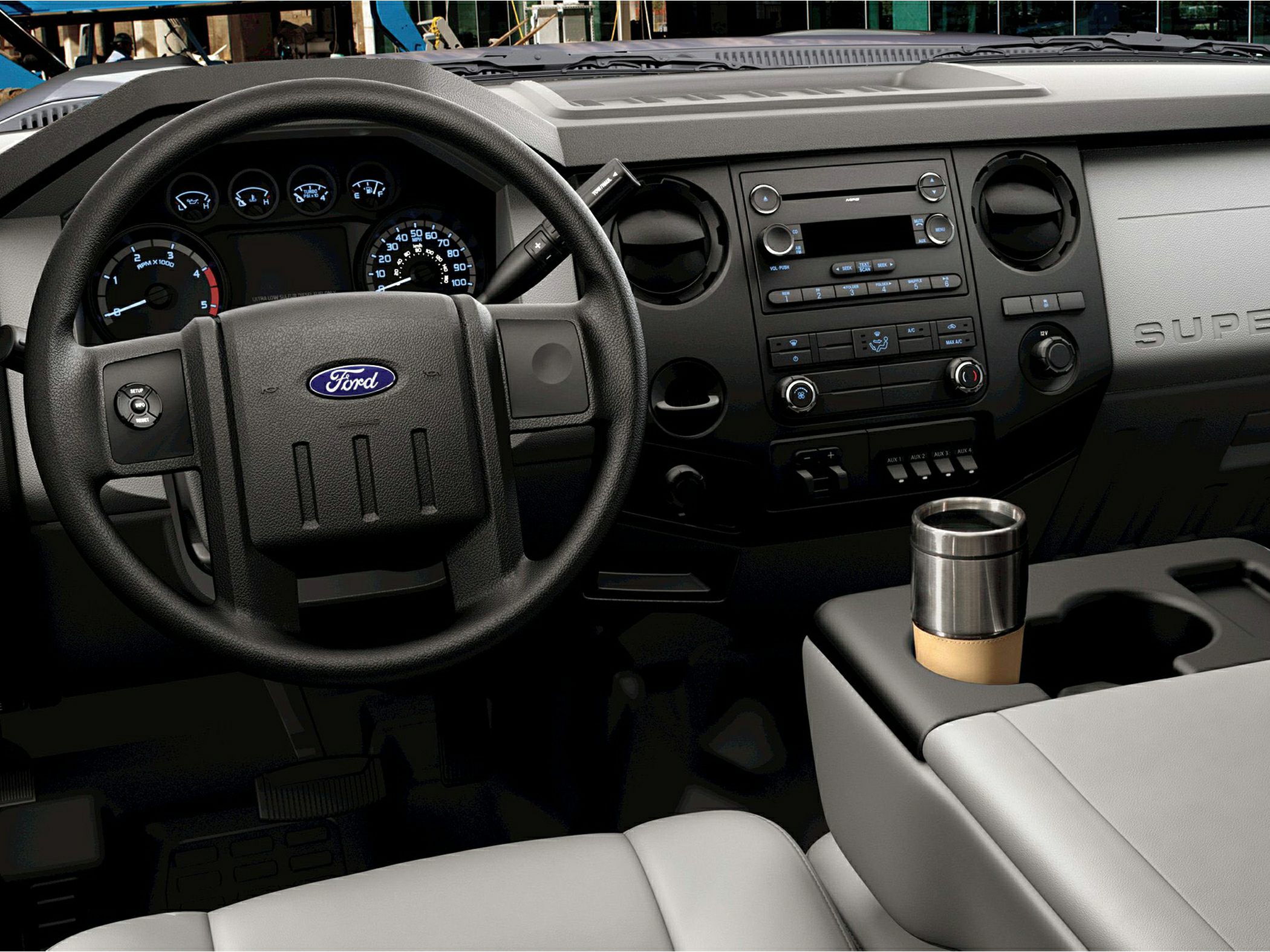Steering wheel, instrument cluster, dashboard, and center console with cup holder and control knobs