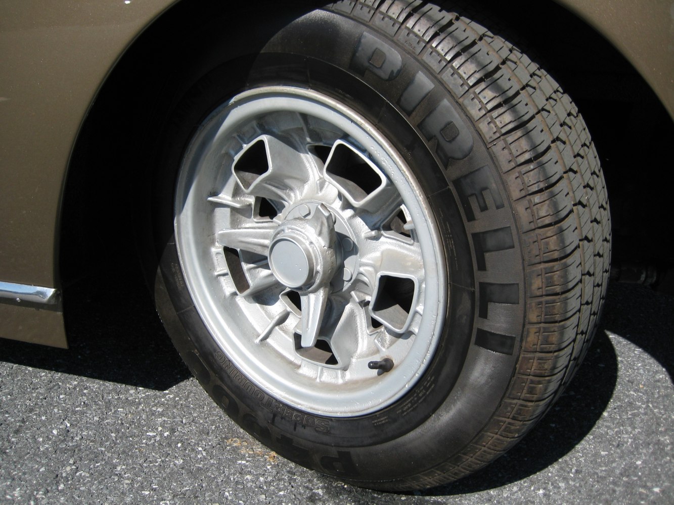 Vintage wheel with central knock-off hub and Michelin Pirelli tire