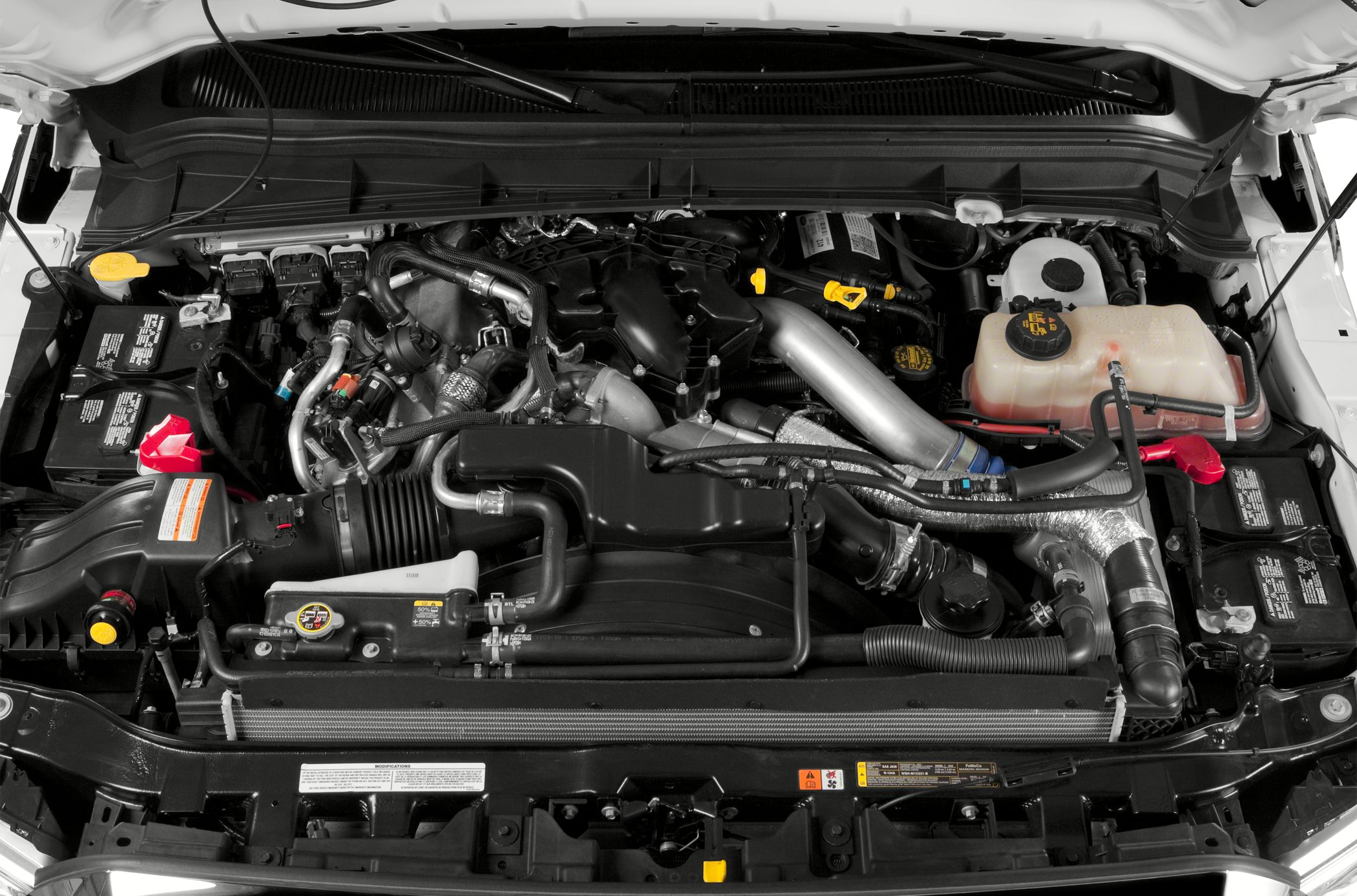 Truck engine bay with turbocharger piping and fluid reservoirs