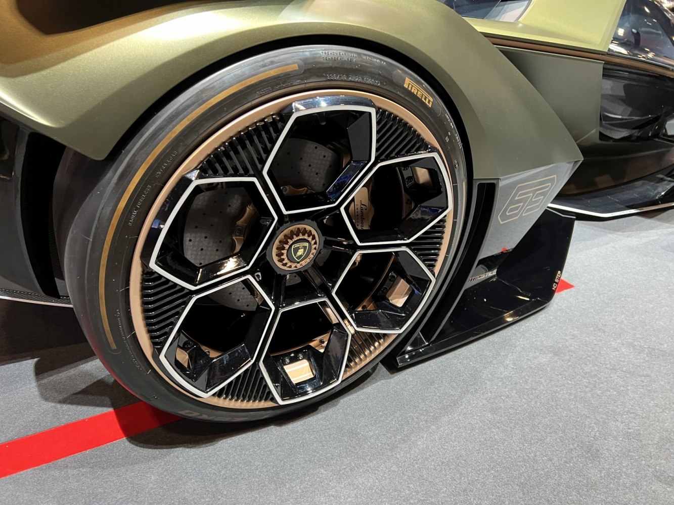 Hexagonal black and chrome alloy wheel with Pirelli tire.