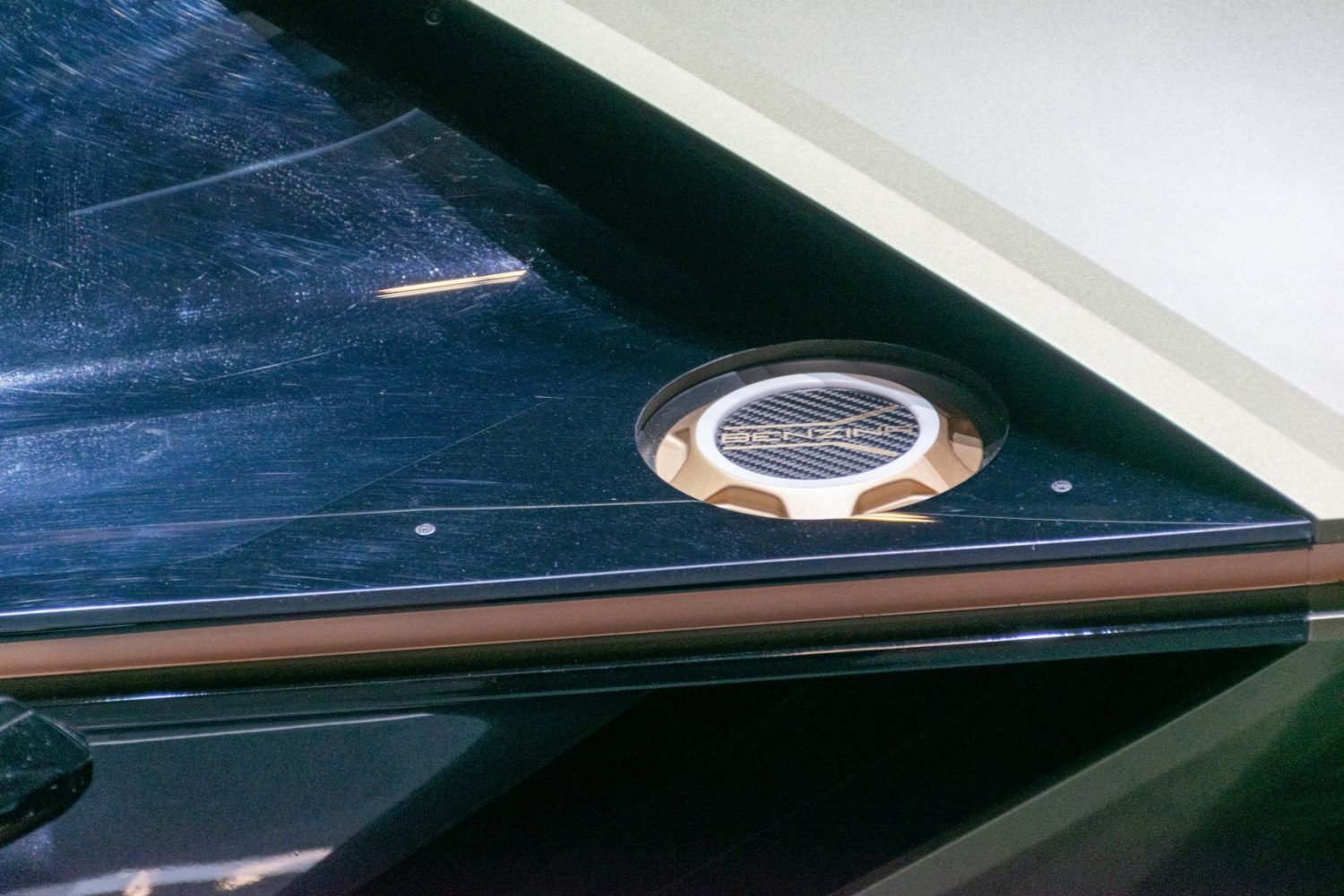 Carbon fiber textured fuel cap detail with black and gold accents